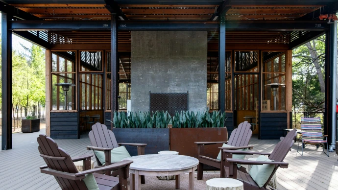 An outdoor patio with a fireplace and adirondack chairs